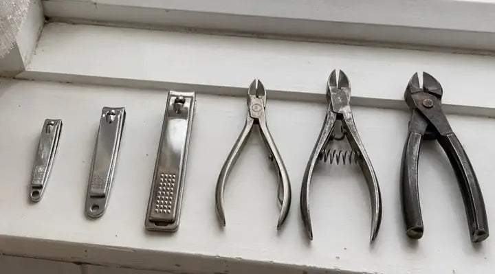 Six pairs of clippers and nippers lined up, smallest to biggest